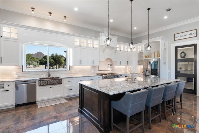 kitchen with crown molding, visible vents, decorative backsplash, appliances with stainless steel finishes, and a sink