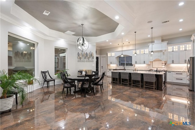 dining area featuring visible vents, marble finish floor, ornamental molding, a raised ceiling, and an inviting chandelier