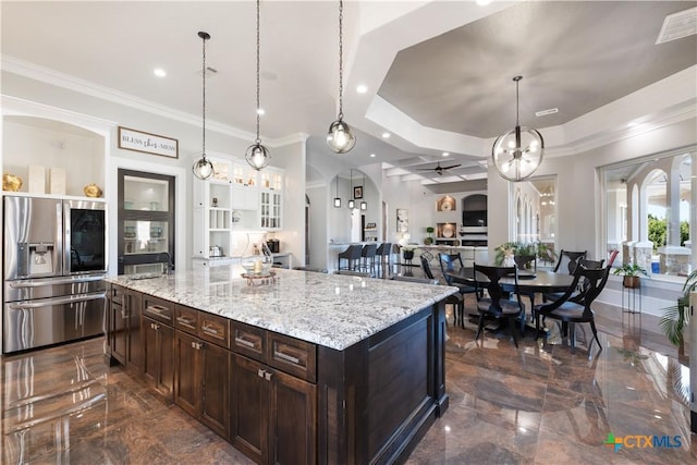 kitchen with arched walkways, visible vents, marble finish floor, stainless steel fridge, and crown molding