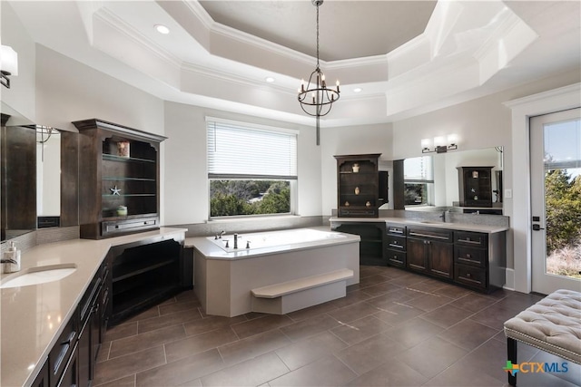 bathroom featuring crown molding, a raised ceiling, and a sink