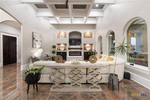 interior space featuring beam ceiling, coffered ceiling, and a high ceiling