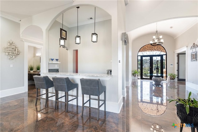 bar featuring marble finish floor, a high ceiling, and baseboards