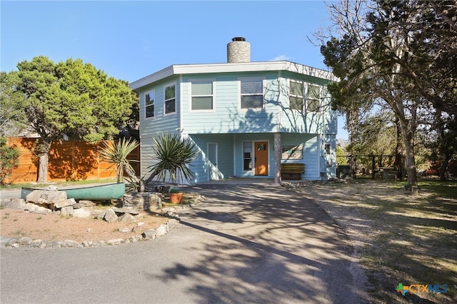 1433 Riviera Dr, Canyon Lake, TX 78133 - view of front of home with driveway, a chimney, and fence