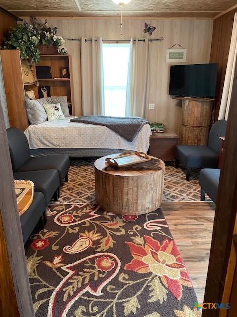 interior space with wood walls, hardwood / wood-style floors, and wood ceiling