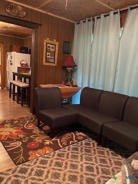 living room with hardwood / wood-style floors and wooden walls