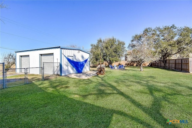 view of yard featuring a fenced backyard, an outbuilding, and a garage