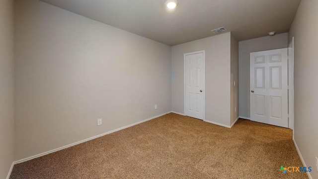 unfurnished bedroom featuring carpet, visible vents, and baseboards