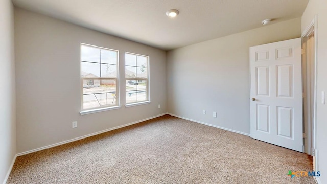 carpeted empty room with baseboards