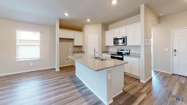 kitchen with a kitchen island with sink, appliances with stainless steel finishes, white cabinets, and a sink