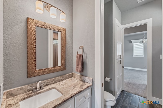 bathroom with wood-type flooring, vanity, and toilet