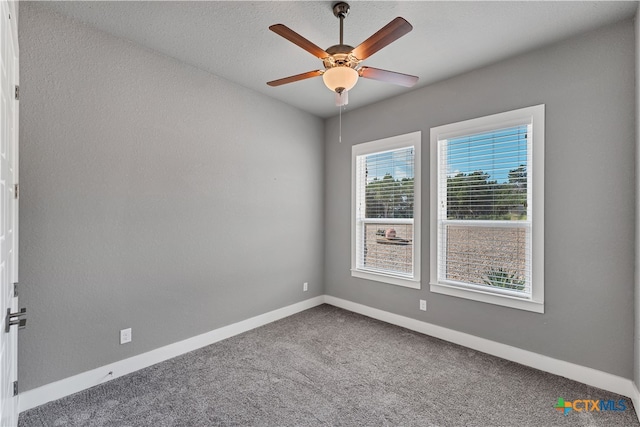 empty room with carpet flooring, a textured ceiling, and ceiling fan