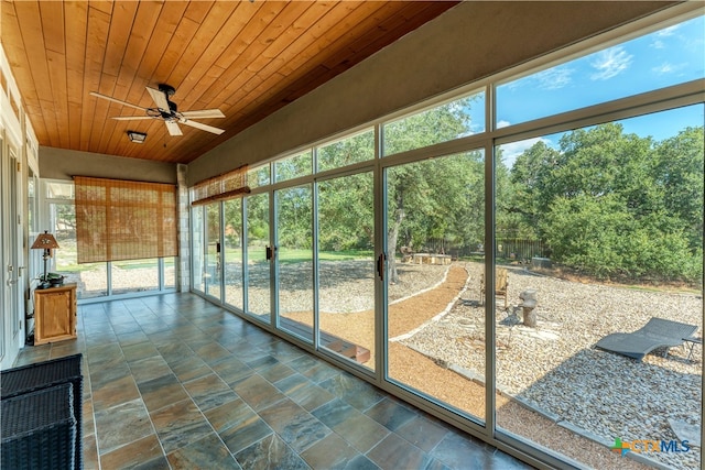 unfurnished sunroom featuring plenty of natural light, ceiling fan, and wood ceiling