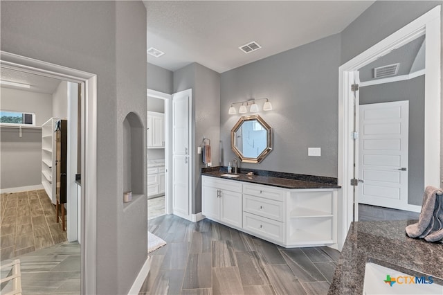 bathroom with wood-type flooring, a textured ceiling, and vanity