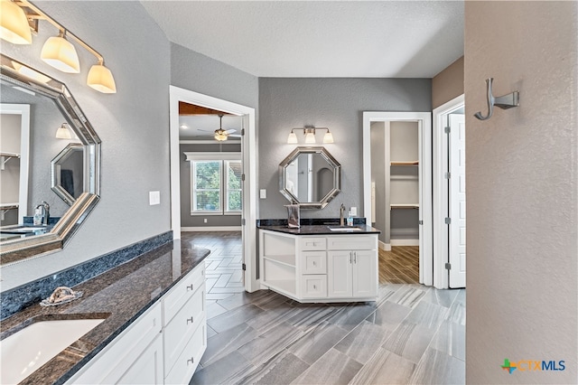 bathroom featuring vanity, hardwood / wood-style floors, ceiling fan, and a textured ceiling