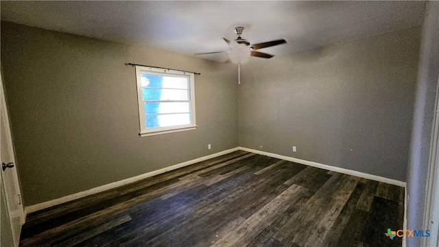 unfurnished room with a ceiling fan, dark wood finished floors, and baseboards