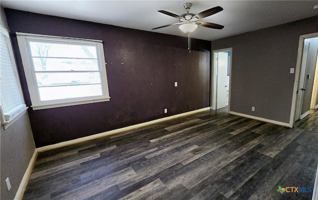 unfurnished room with wood finished floors, a ceiling fan, and baseboards