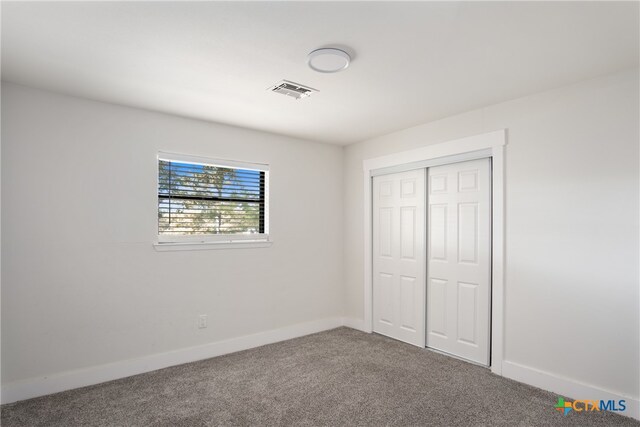 unfurnished bedroom with carpet flooring and a closet