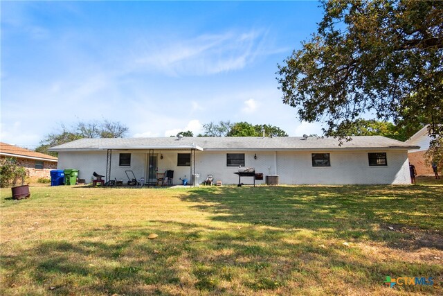 back of house with a lawn and a patio area