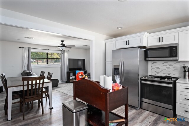 kitchen featuring white cabinets, wood-type flooring, and appliances with stainless steel finishes