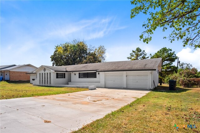 ranch-style home featuring a garage and a front yard