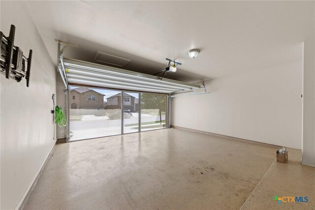 garage with baseboards and a garage door opener