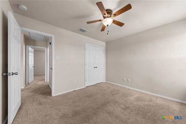 unfurnished bedroom featuring visible vents, baseboards, attic access, and carpet floors