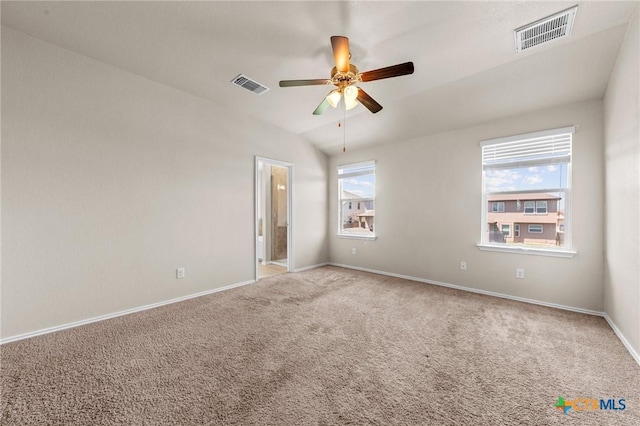 carpeted empty room featuring baseboards, a ceiling fan, visible vents, and lofted ceiling
