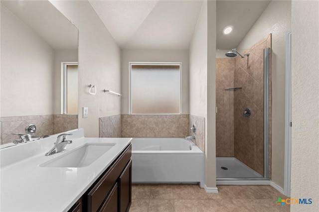 bathroom featuring vanity, a shower stall, tile patterned flooring, and a garden tub