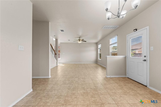 foyer featuring ceiling fan with notable chandelier, baseboards, visible vents, and stairway