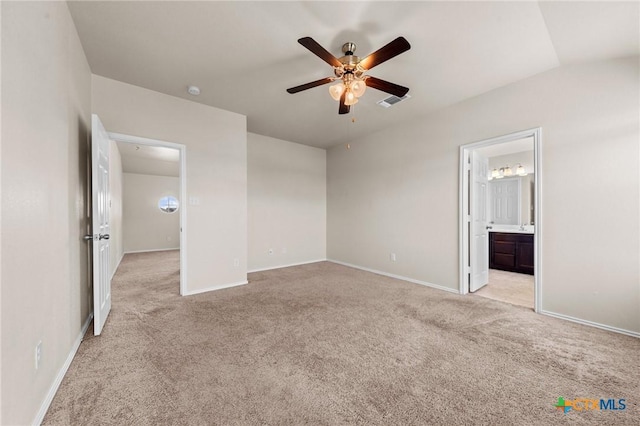 unfurnished bedroom featuring ensuite bath, visible vents, baseboards, and light colored carpet