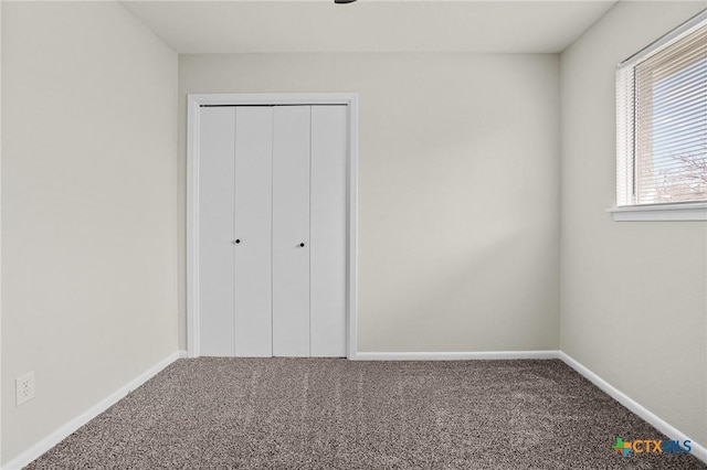 unfurnished bedroom with a closet, multiple windows, and carpet