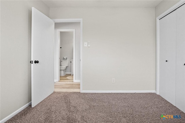 unfurnished bedroom with a closet and light carpet