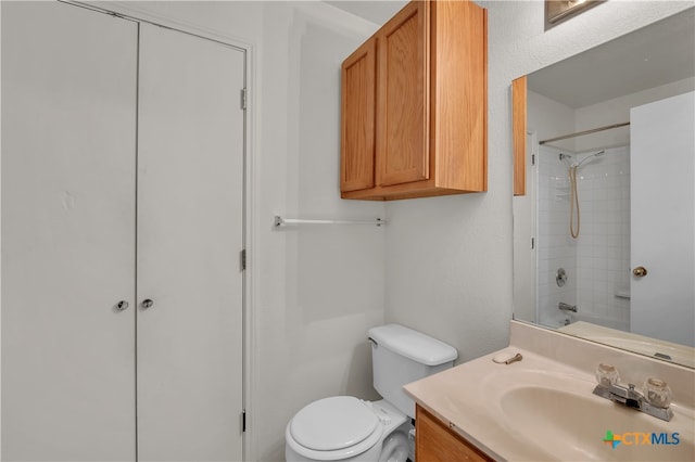 full bathroom featuring toilet, vanity, and tiled shower / bath