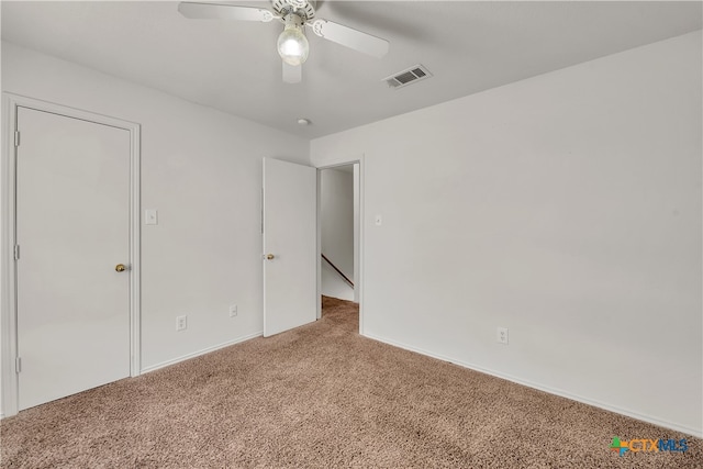 carpeted spare room with ceiling fan