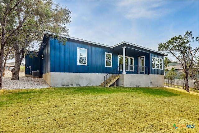 rear view of property featuring central AC unit and a yard