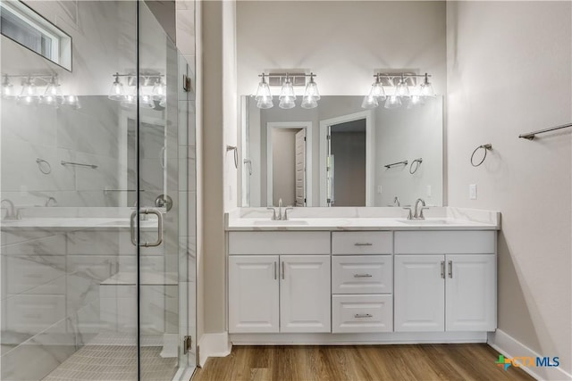 bathroom with hardwood / wood-style flooring, vanity, and a shower with shower door