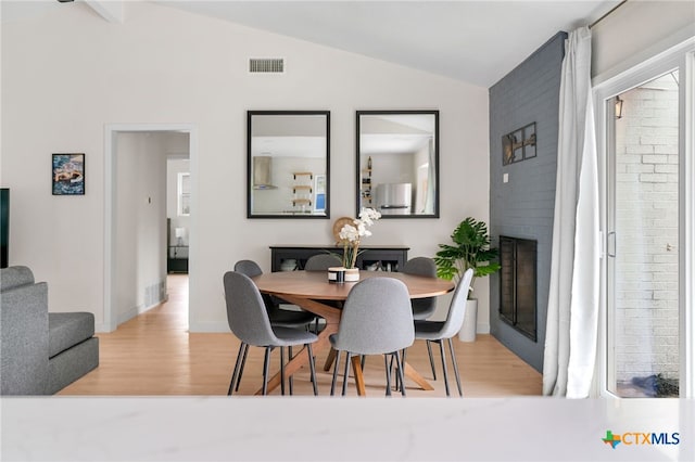 1107 Chesapeake Dr, Austin, TX 78758 - dining area with vaulted ceiling, wood finished floors, a fireplace, and baseboards