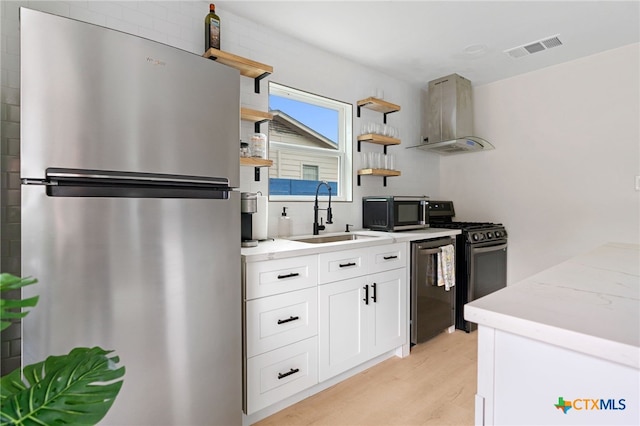 1107 Chesapeake Dr, Austin, TX 78758 - kitchen with stainless steel appliances, open shelves, exhaust hood, a sink, and light wood-style floors