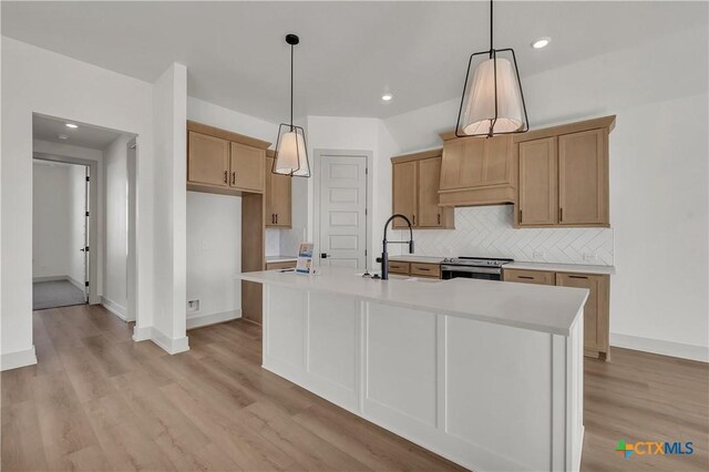 5019 Fence Line Trl, Nolanville, TX 76559 - kitchen featuring stainless steel range with electric cooktop, light wood-style floors, light countertops, a kitchen island with sink, and tasteful backsplash