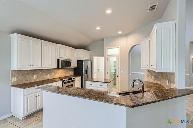 503 Wilderness Way, New Braunfels, TX 78132 - kitchen featuring stainless steel appliances, arched walkways, dark stone countertops, backsplash, and a center island