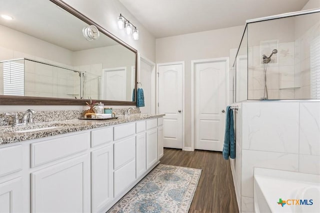 1330 Logan Blvd, Salado, TX 76571 - bathroom with tiled shower, double vanity, a bath, wood finished floors, and recessed lighting