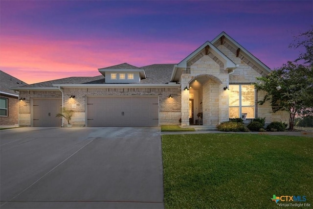 1330 Logan Blvd, Salado, TX 76571 - french provincial home featuring an attached garage, concrete driveway, a yard, a shingled roof, and brick siding