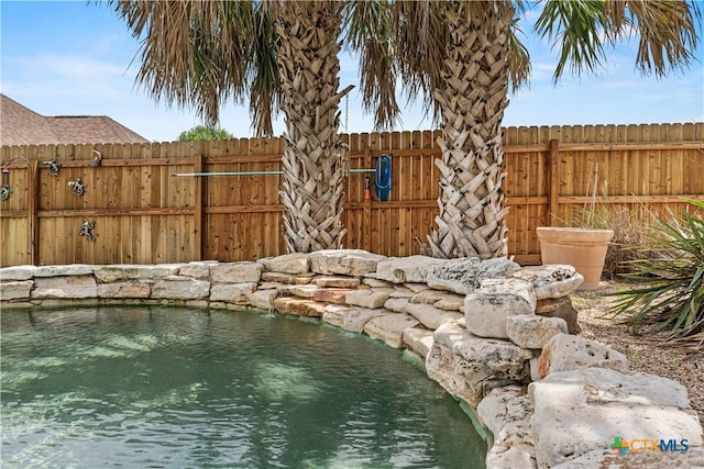 view of swimming pool with fence