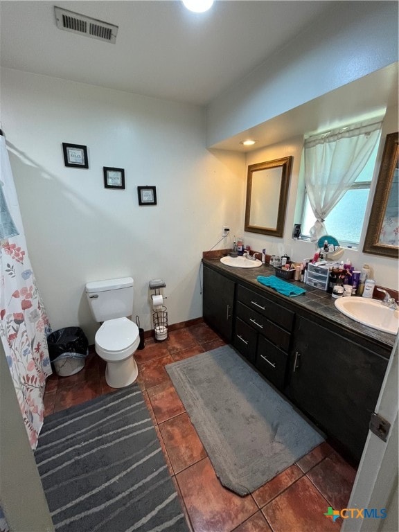 bathroom with vanity, tile patterned floors, and toilet