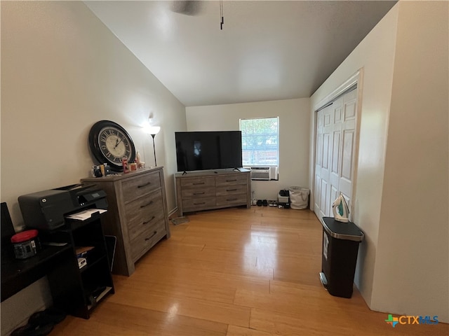 bedroom with a closet, cooling unit, vaulted ceiling, and light hardwood / wood-style floors