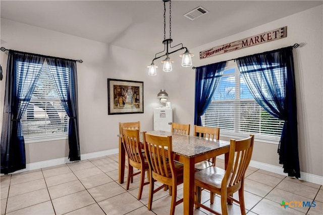 dining room featuring light tile patterned floors, baseboards, and visible vents