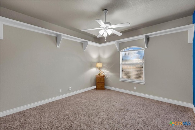 spare room featuring baseboards, carpet floors, and a ceiling fan