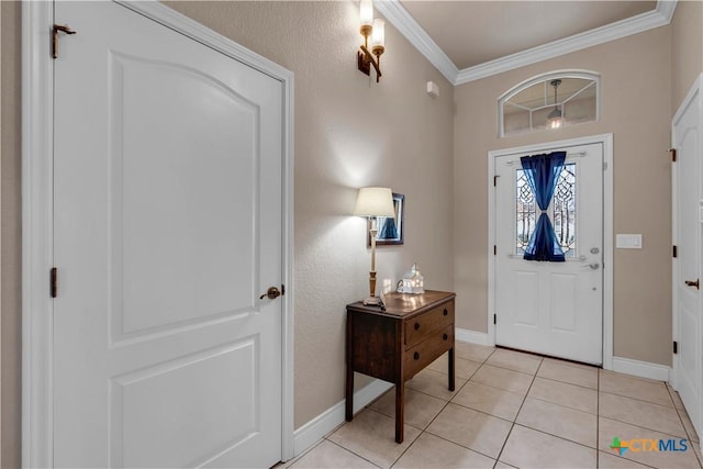 foyer featuring light tile patterned floors, crown molding, and baseboards