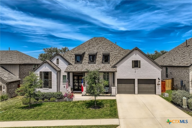 french provincial home featuring a garage, a front lawn, and covered porch