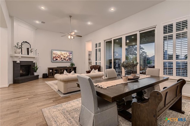 108 Rainbow Valley Trl, San Marcos, TX 78666 - dining area featuring light wood-style flooring, ceiling fan, recessed lighting, a brick fireplace, and baseboards